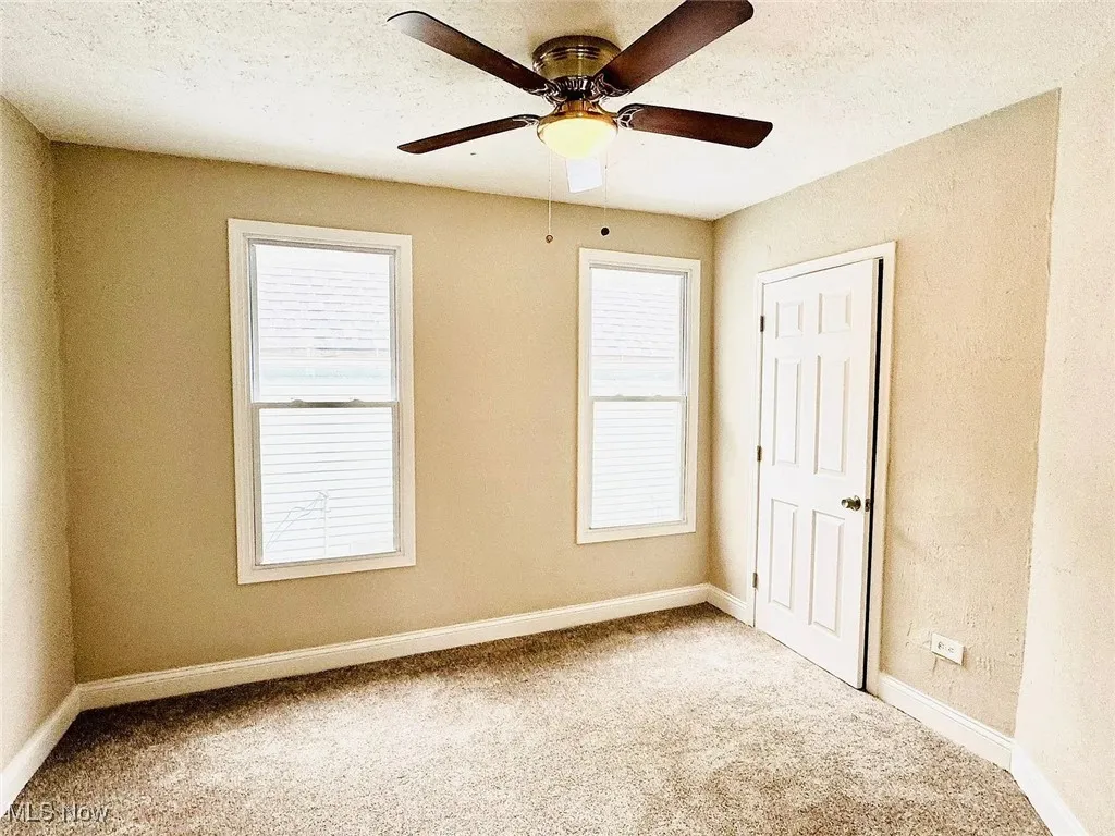 Unfurnished bedroom with carpet, baseboards, and a ceiling fan