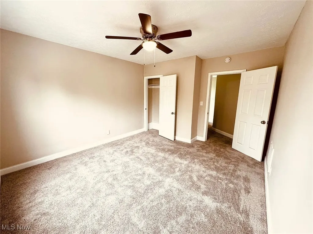 Unfurnished bedroom featuring carpet, a closet, baseboards, and ceiling fan