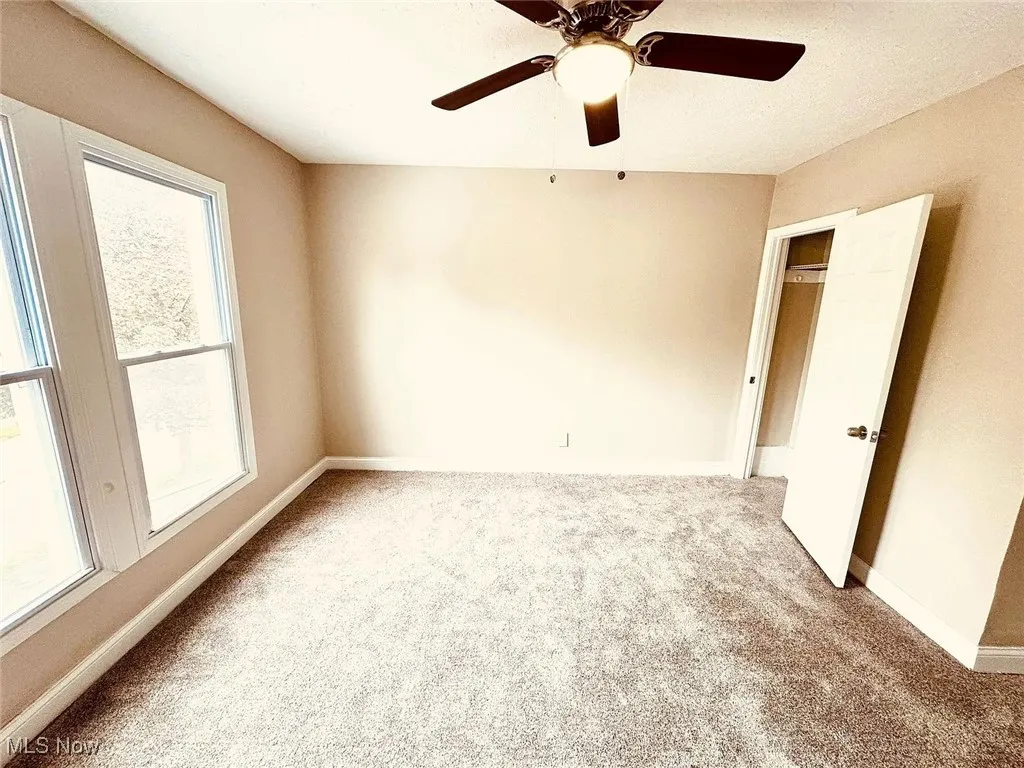 Unfurnished bedroom with carpet flooring, baseboards, and a ceiling fan