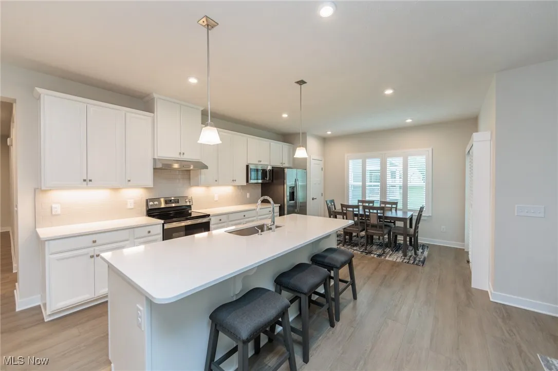 Kitchen with dining area, quartz countertop- SS applinces- tile backsplash - vinyl floor