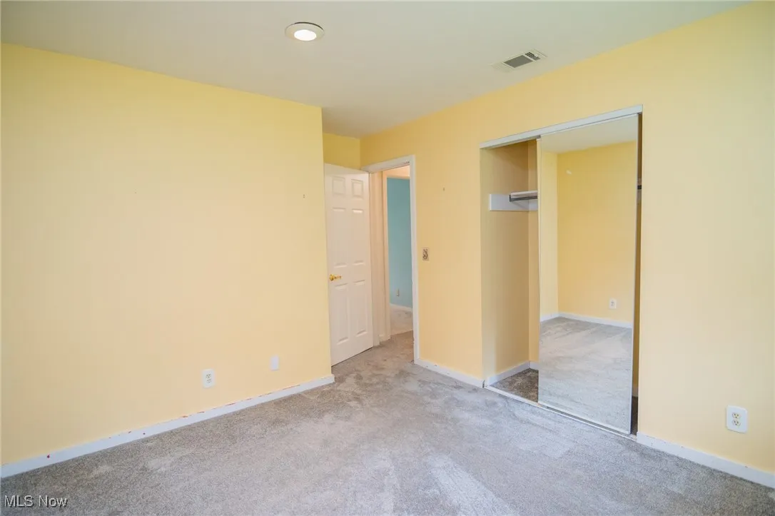Unfurnished bedroom with carpet floors, baseboards, and a closet