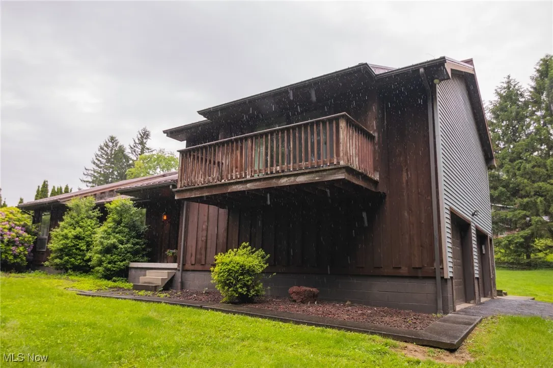 Back of house featuring a lawn and a wooden deck