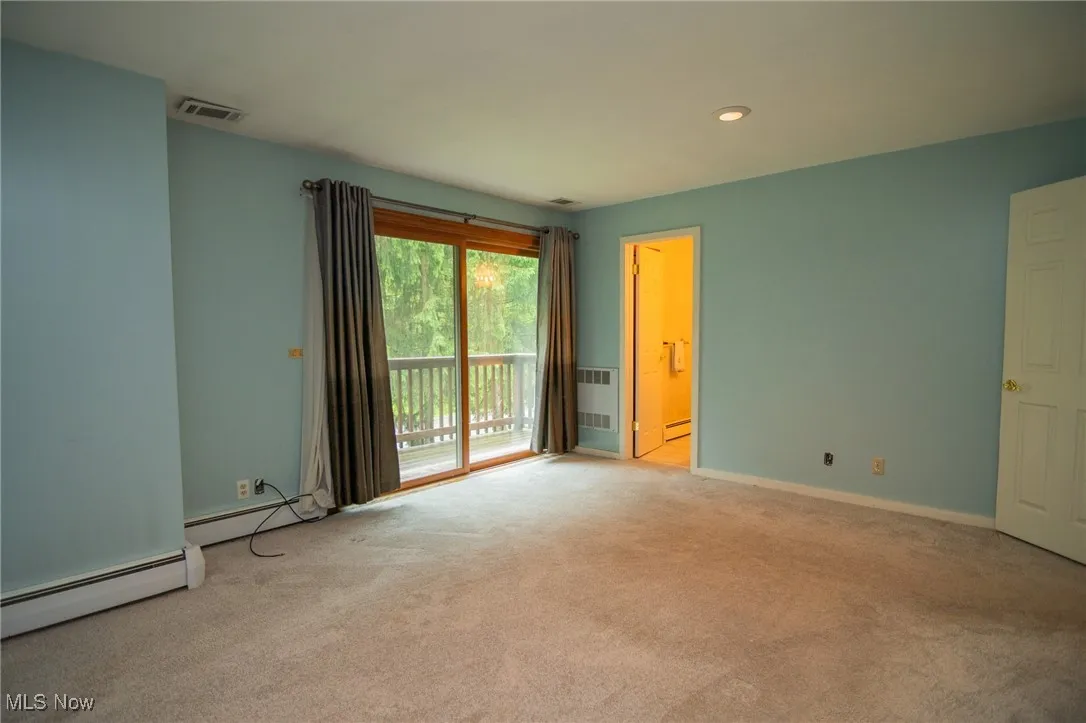 Carpeted spare room with a baseboard heating unit, baseboards, and recessed lighting