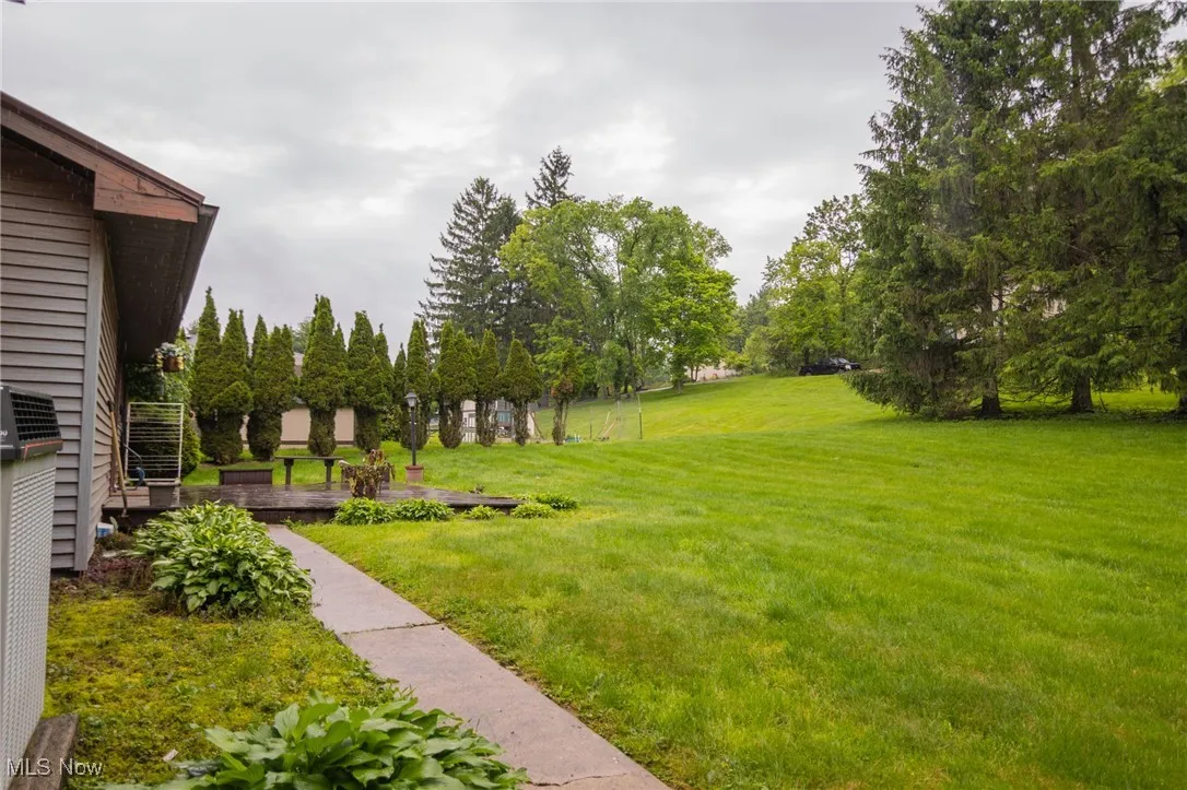 View of green lawn with view of wooded area