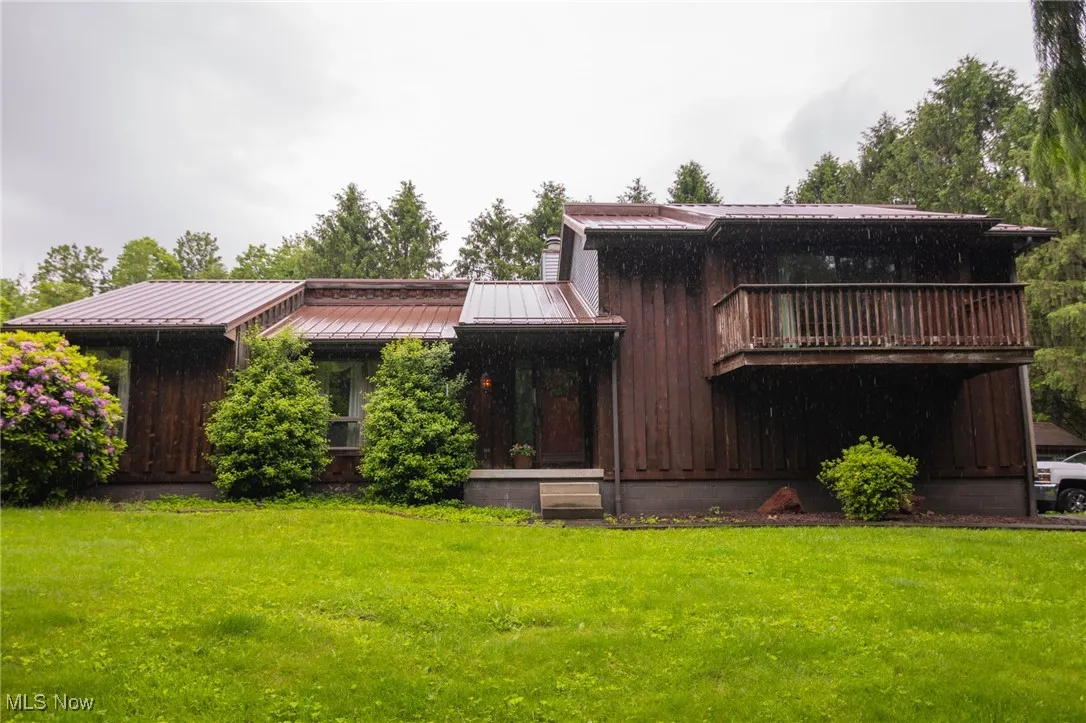 Rear view of property featuring a yard, metal roof, and a standing seam roof