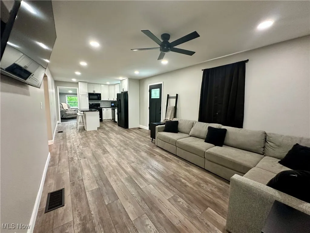 Living room featuring light wood-type flooring, a ceiling fan, recessed lighting, healthy amount of natural light, and baseboards