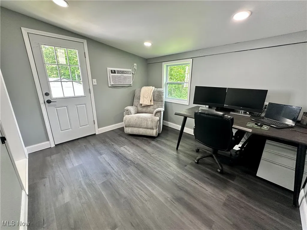 Office area with an AC wall unit, lofted ceiling, wood finished floors, and recessed lighting