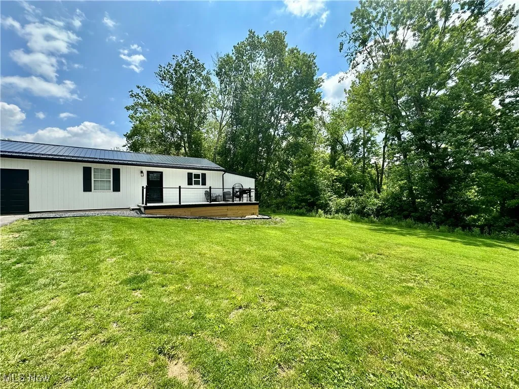 View of grassy yard with a deck