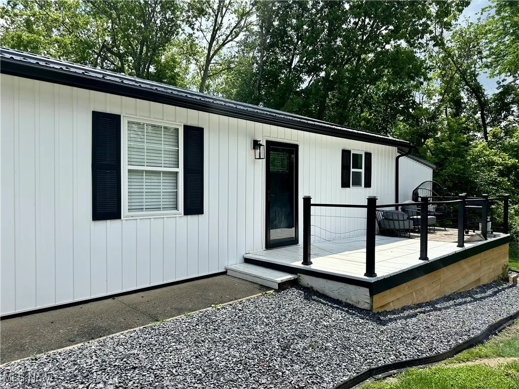 Property entrance featuring a deck and metal roof