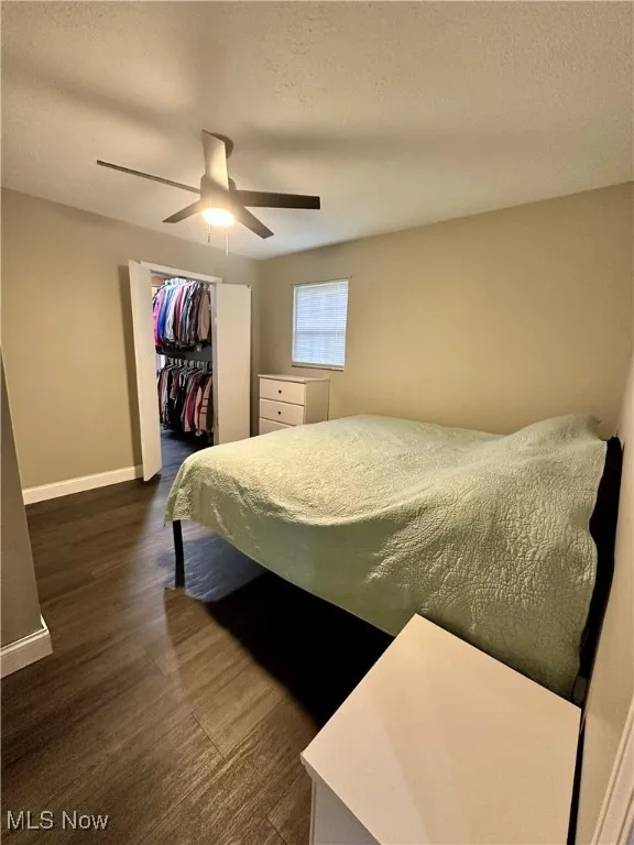Bedroom with baseboards, a ceiling fan, a closet, and a textured ceiling