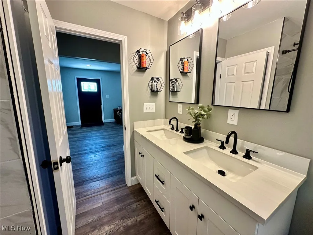 Bathroom featuring double vanity and wood finished floors