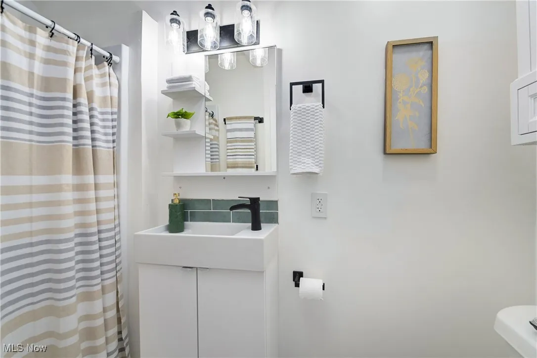 Bathroom featuring vanity and curtained shower