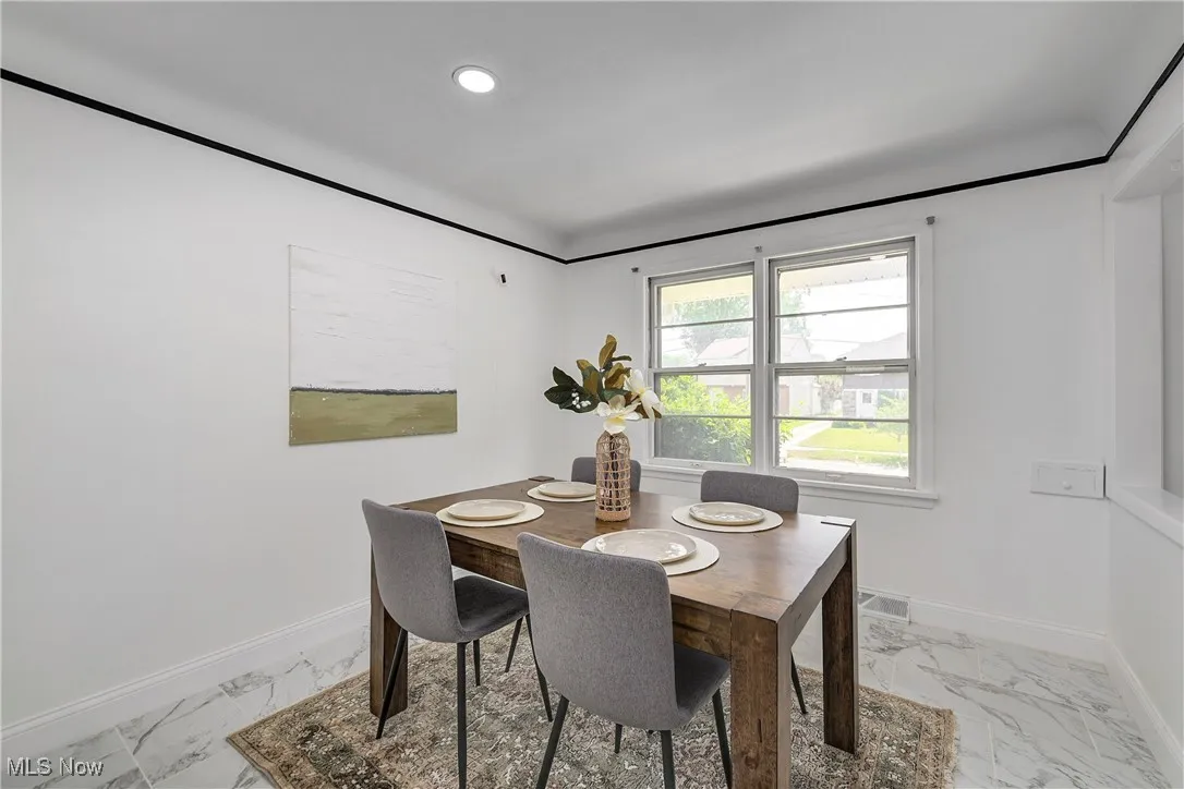 Dining room featuring marble finish flooring and recessed lighting