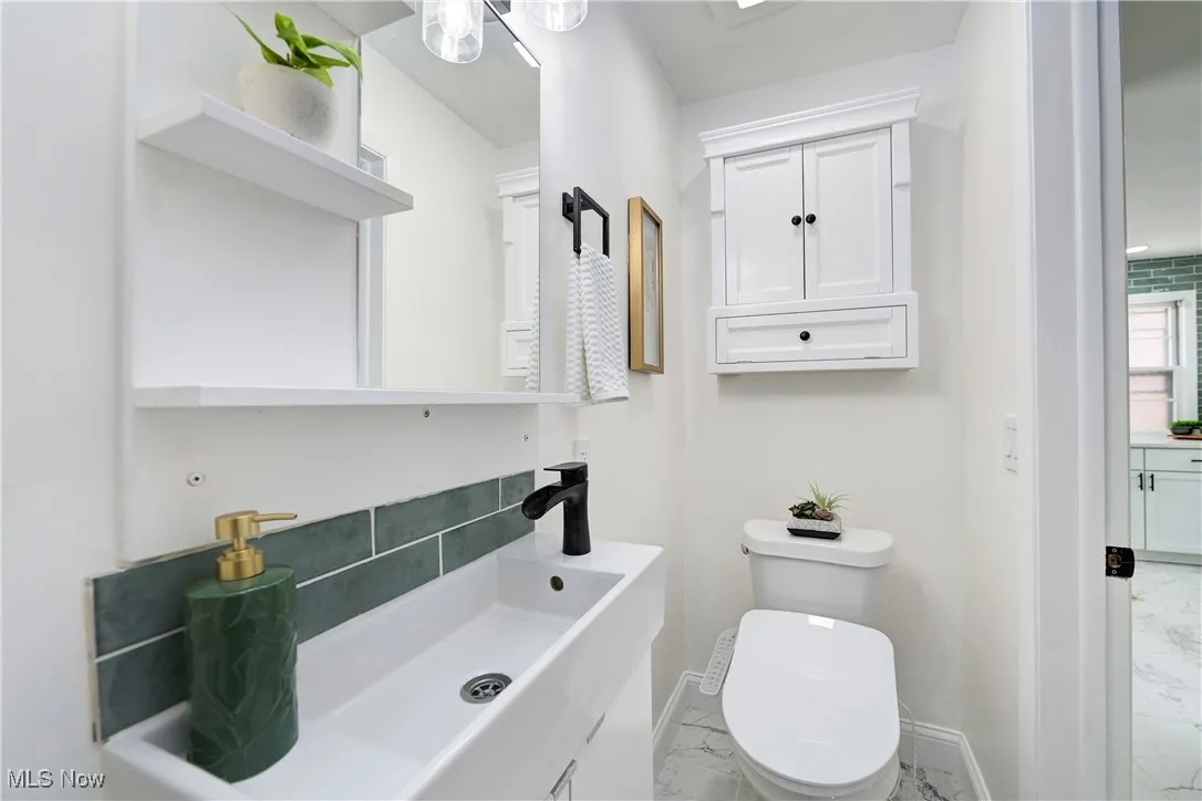Bathroom featuring marble look tile flooring and vanity