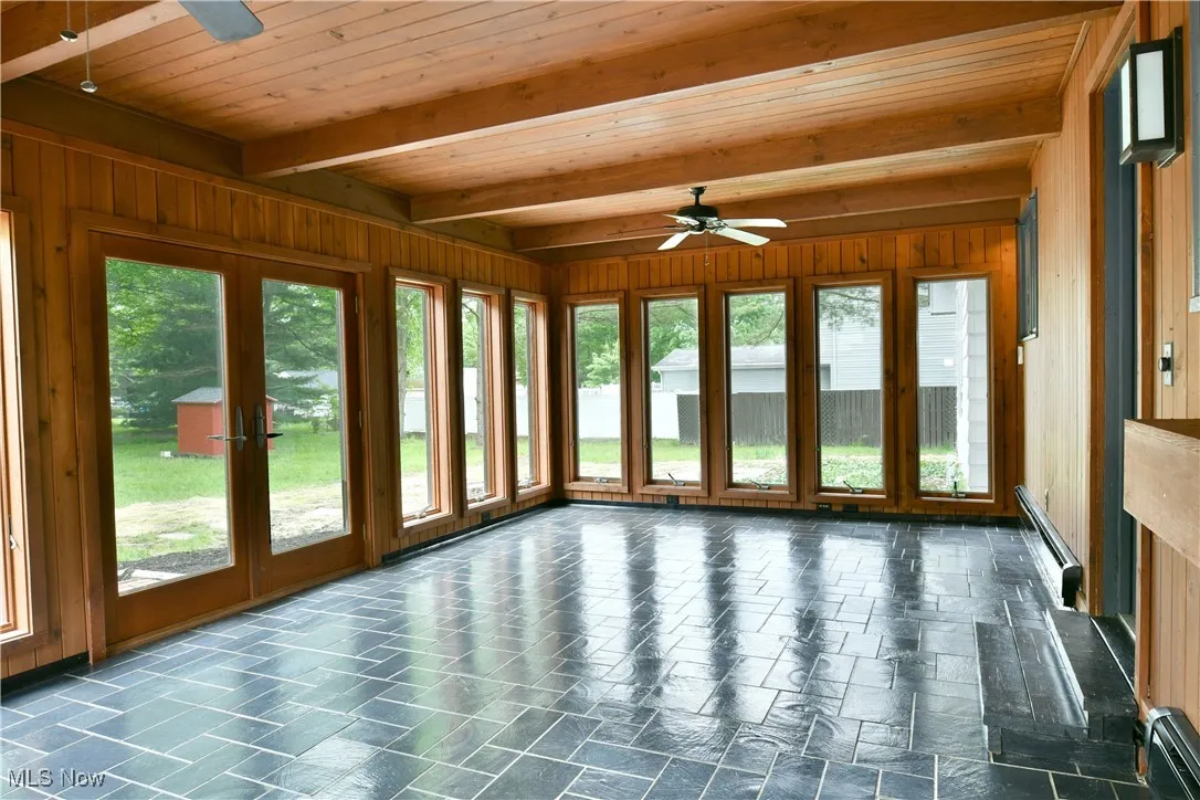 Unfurnished sunroom with french doors, beam ceiling, and a baseboard heating unit