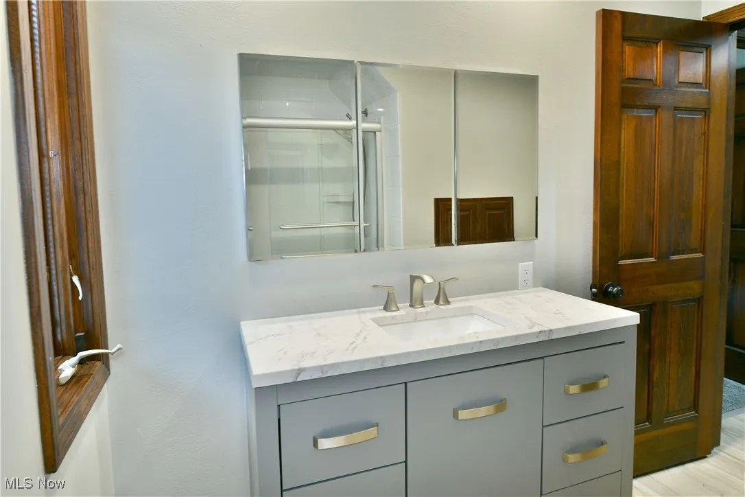 Bathroom with vanity and a shower with door