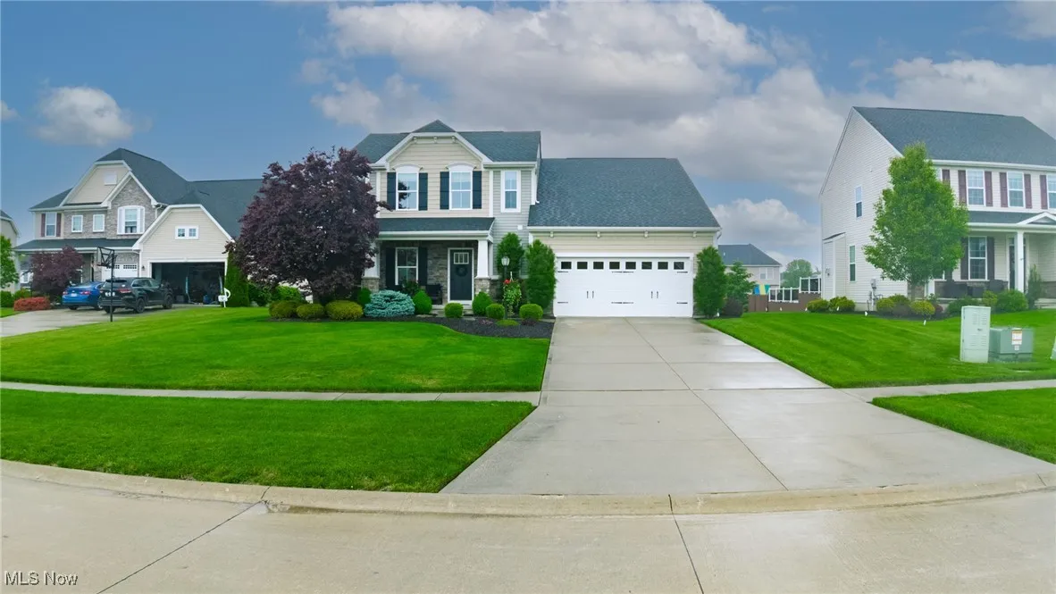 View of front of property with concrete driveway, an attached garage, a front yard, and a residential view