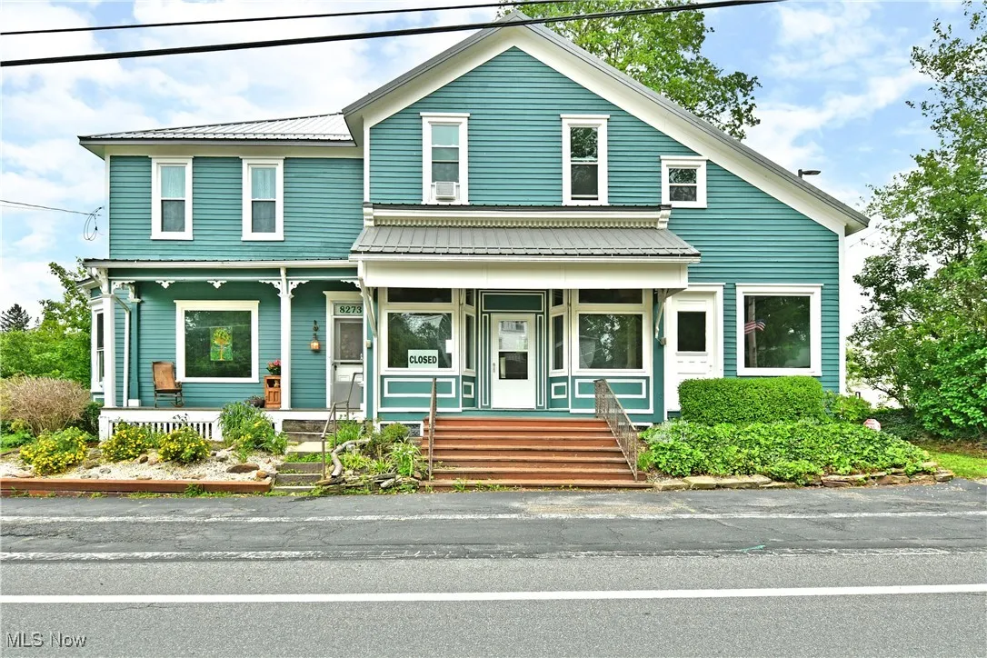 View of front facade featuring covered porch and metal roof