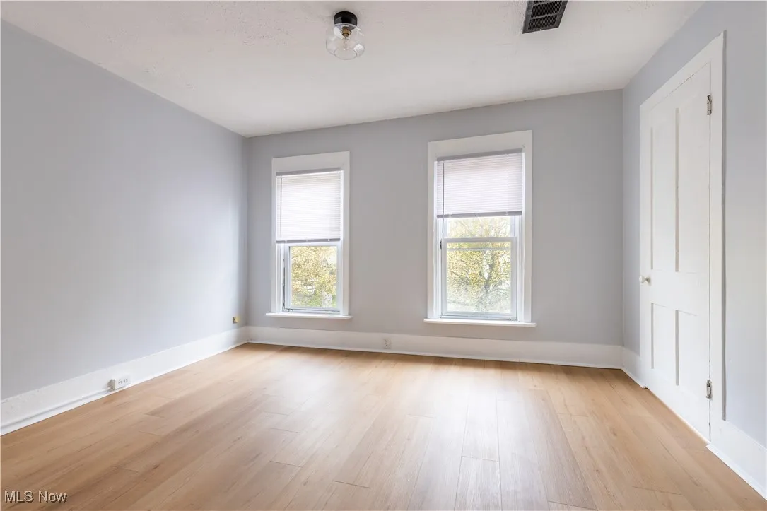 Spare room featuring light wood-style floors and baseboards