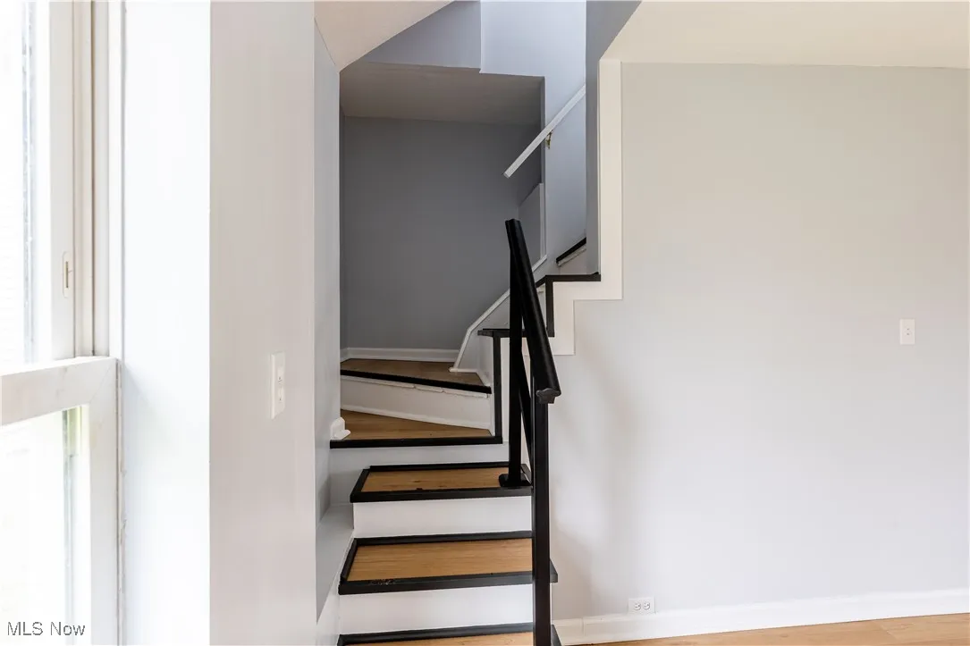 Staircase featuring wood finished floors and baseboards
