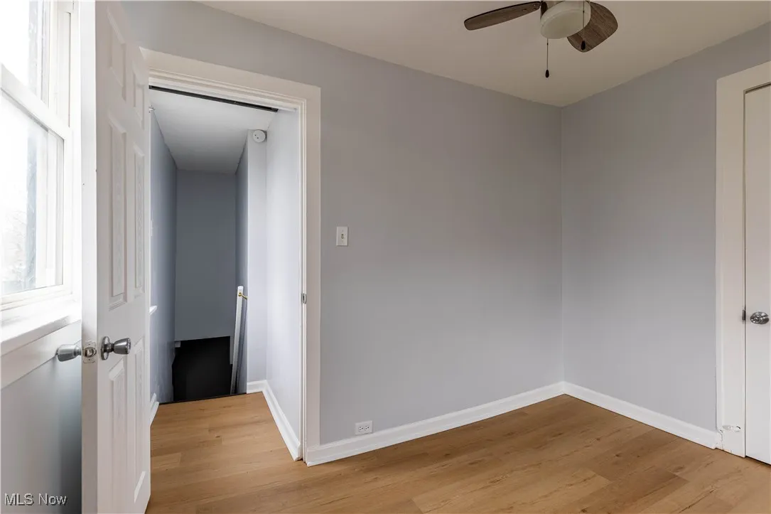 Spare room featuring a ceiling fan, light wood-type flooring, and baseboards