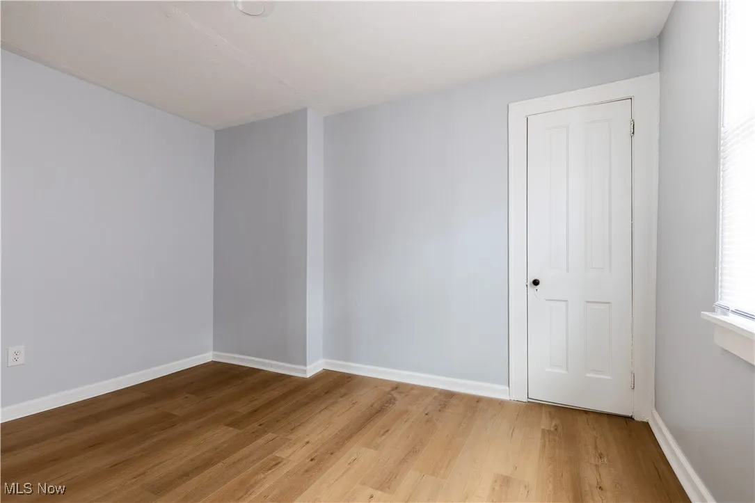 Empty room with light wood finished floors and baseboards