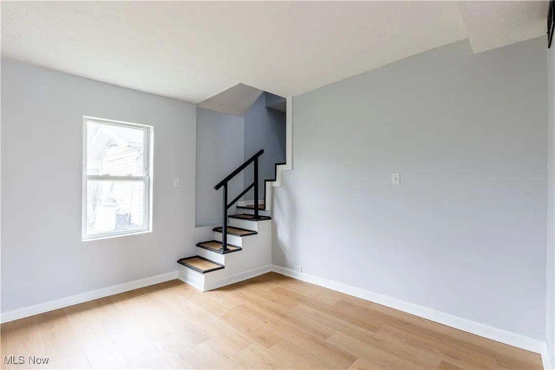 Stairs with wood finished floors and baseboards