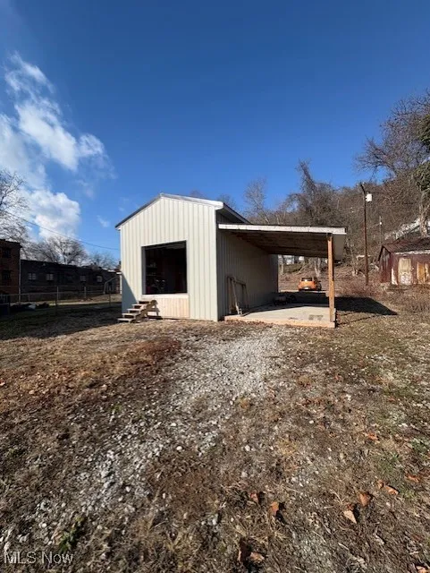View of outbuilding featuring entry steps and a carport
