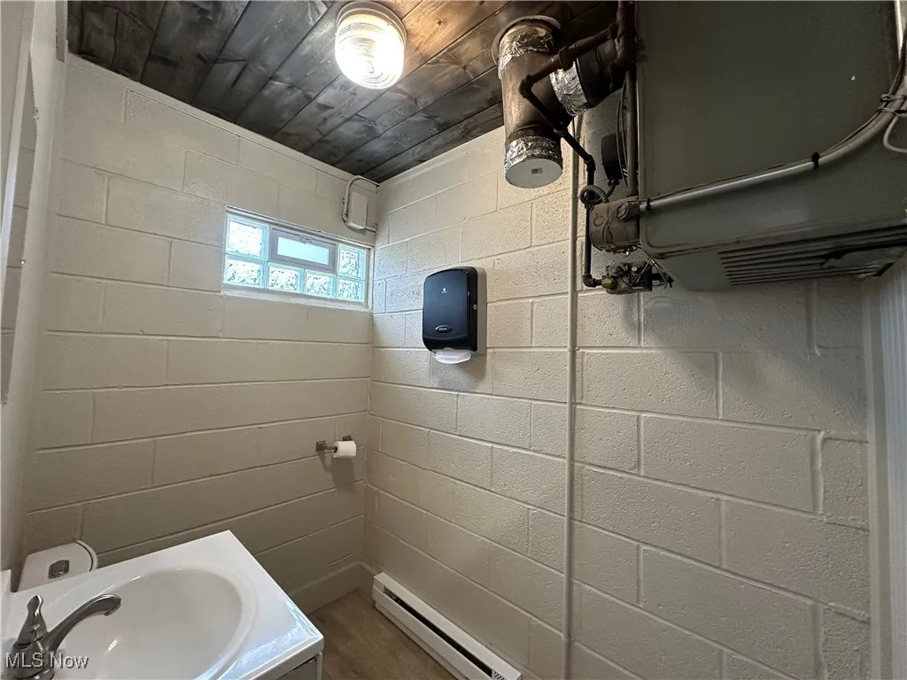 Smaller building,Bathroom with a baseboard radiator and vanity. New floor, wood ceiling, baseboard heat, toilet
