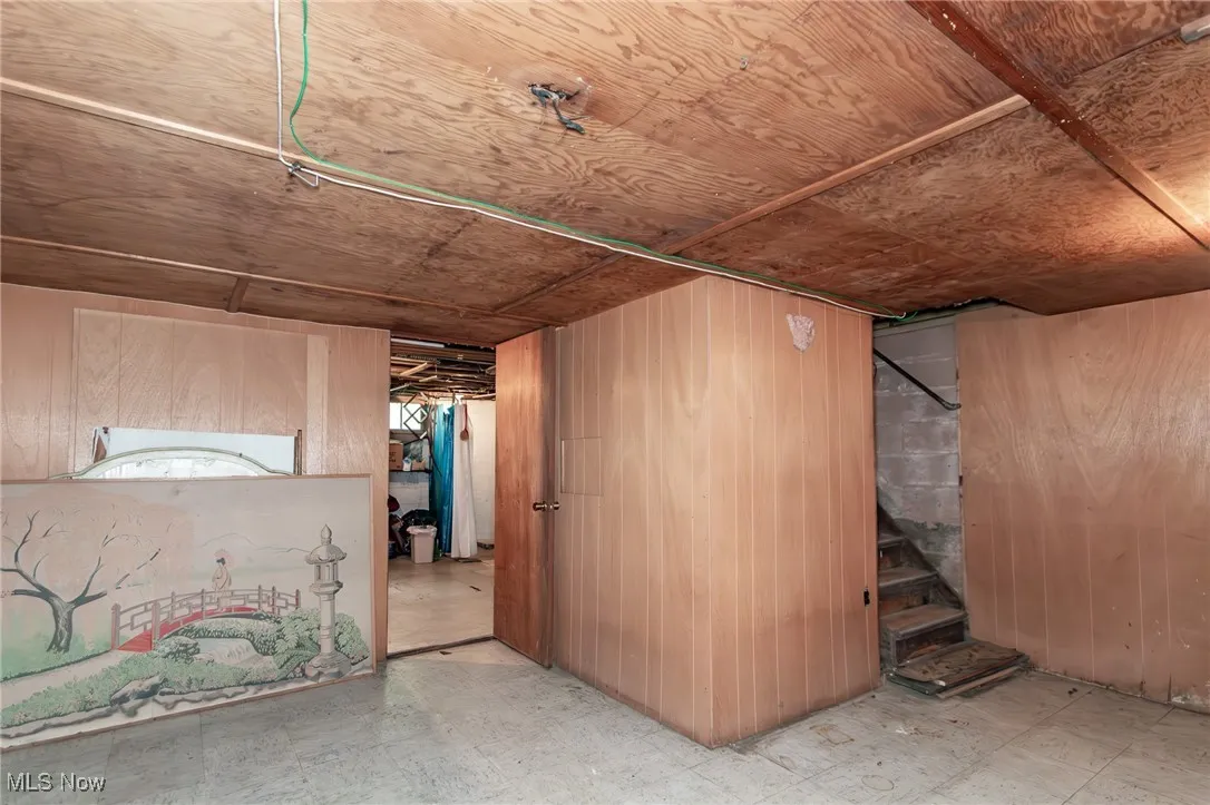 Below grade area with wood walls and tile patterned floors