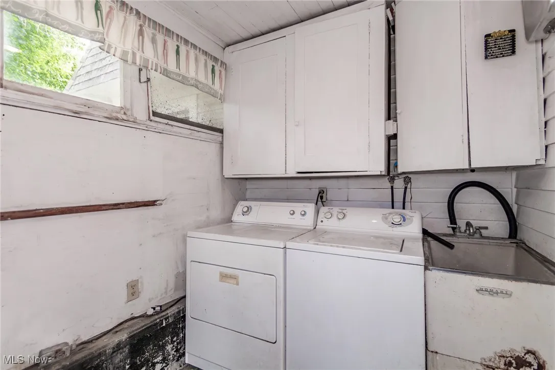 Washroom featuring cabinet space and washer and clothes dryer