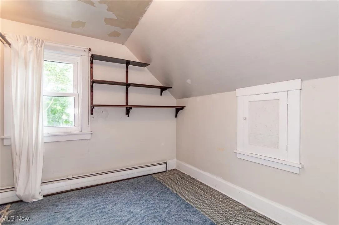 Bonus room with carpet flooring, a baseboard heating unit, vaulted ceiling, and baseboards