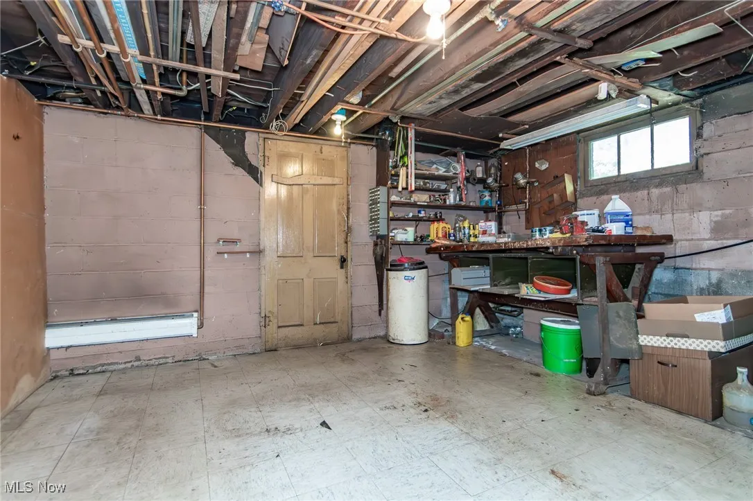 Basement featuring tile patterned floors and concrete block wall