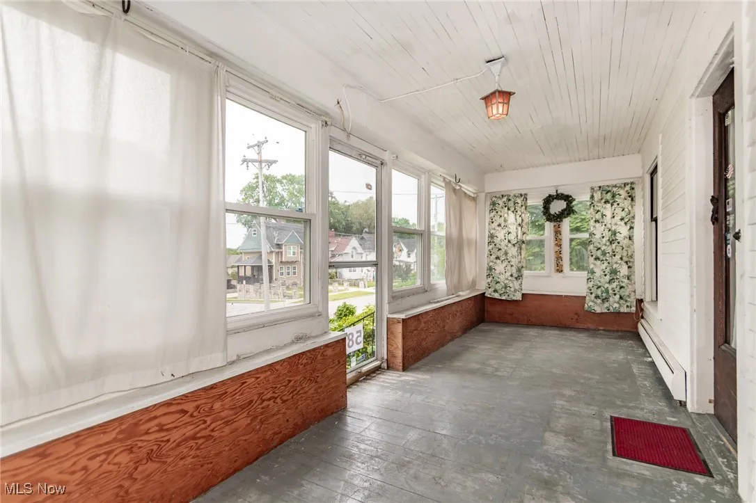 Unfurnished sunroom featuring a baseboard radiator