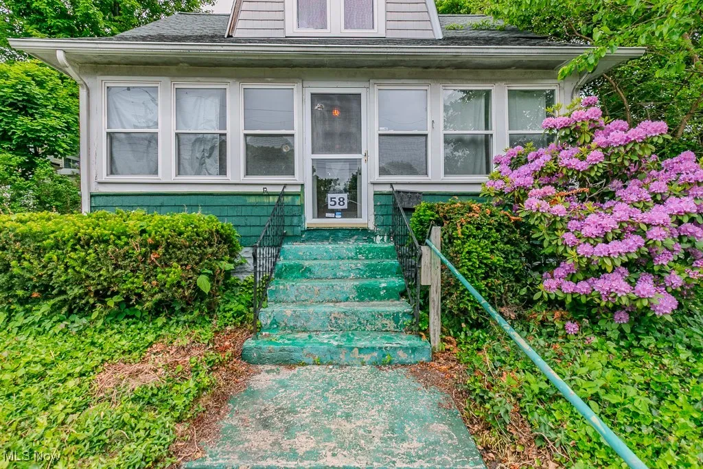 Doorway to property featuring a shingled roof