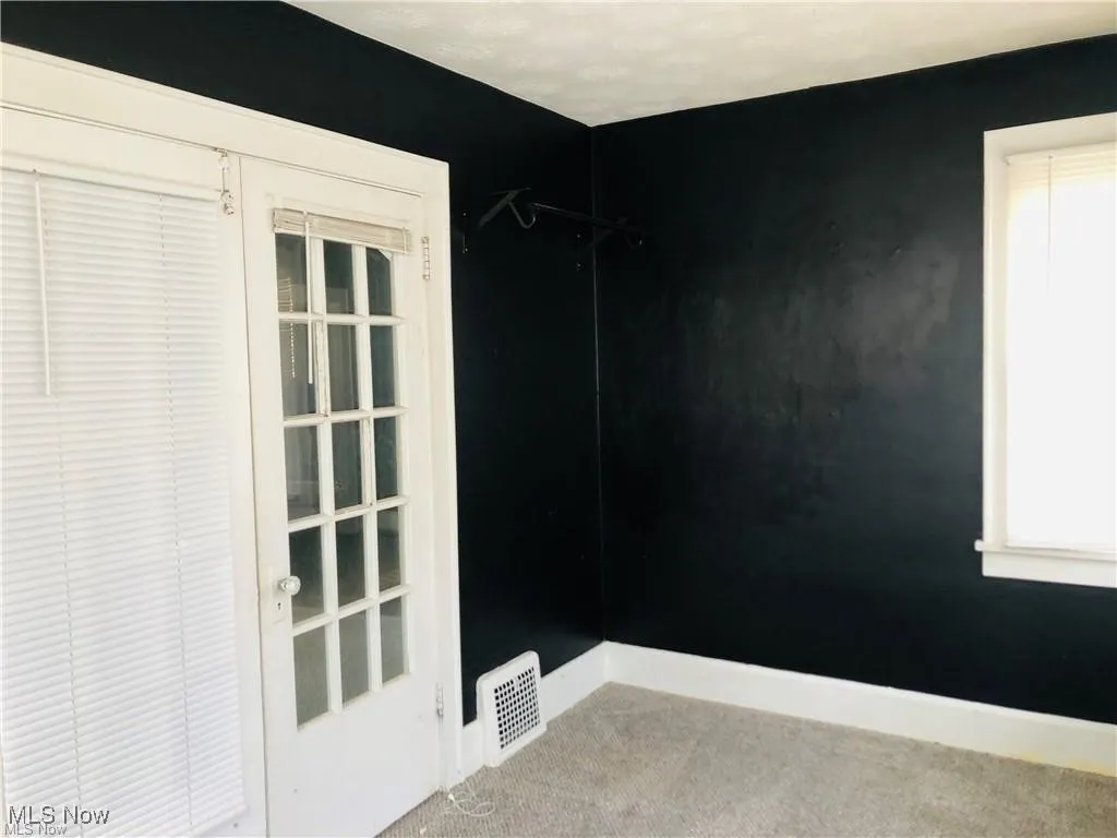 Empty room with carpet flooring and baseboards