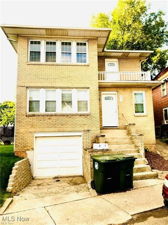 View of front of home with brick siding and a balcony