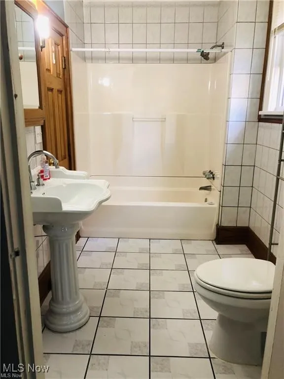 Full bathroom featuring toilet, shower / bathtub combination, and marble finish floors