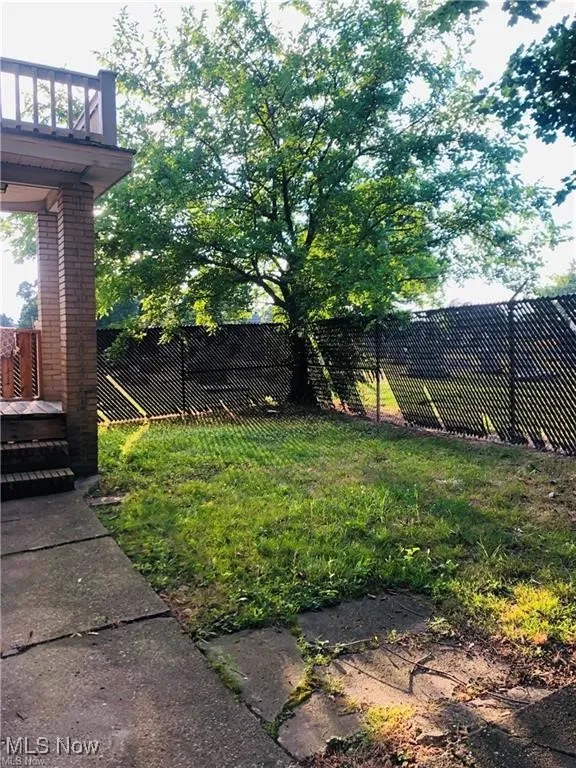 Fenced backyard with a balcony