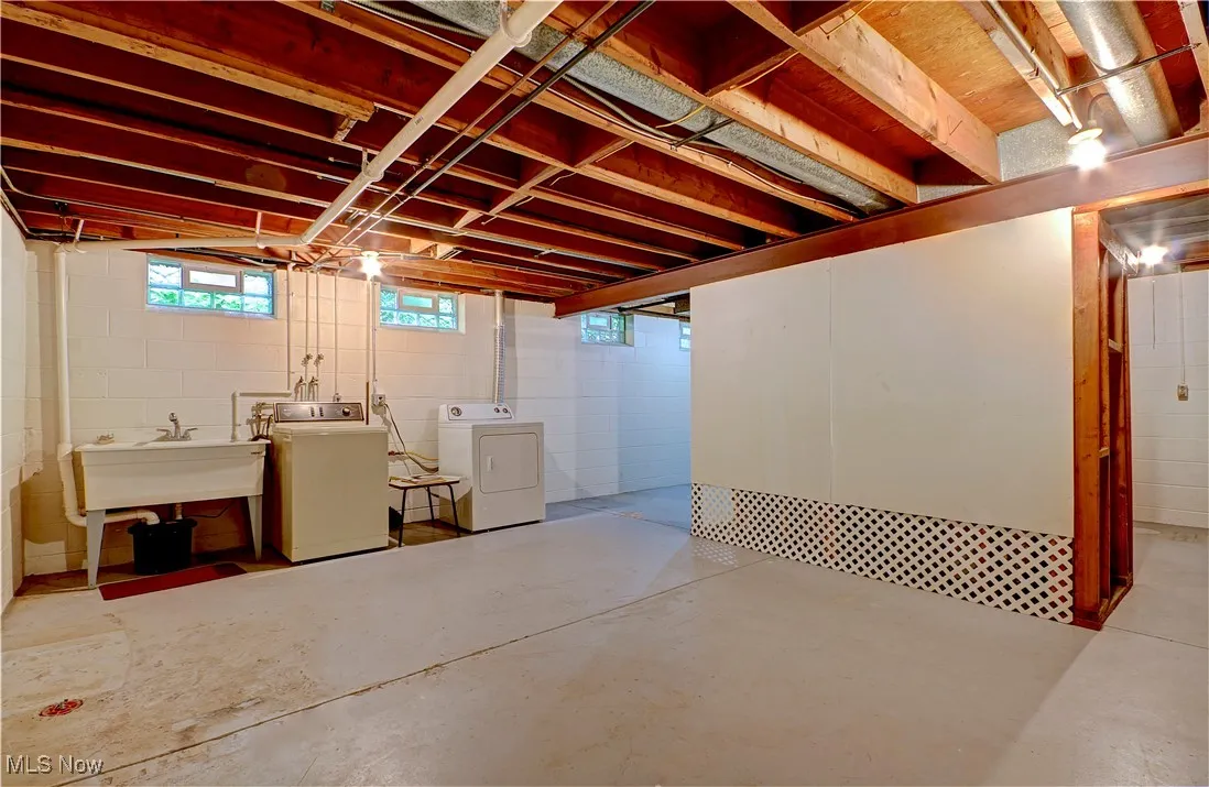 Basement featuring separate washer and dryer and a sink