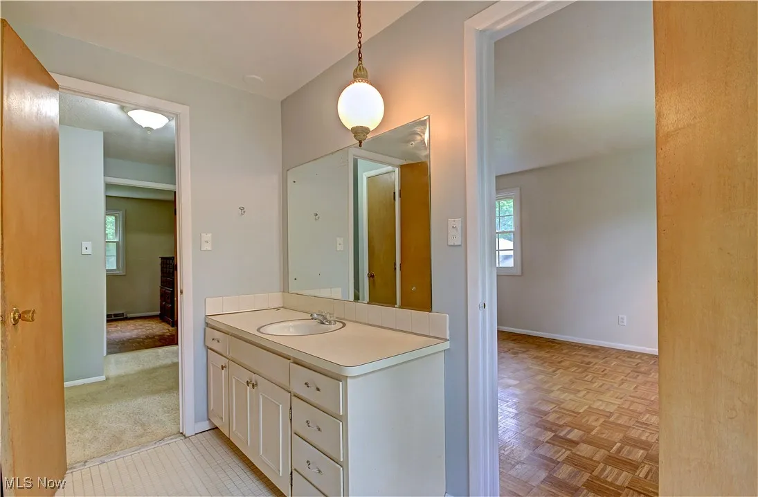 Bathroom with healthy amount of natural light, vanity, and baseboards