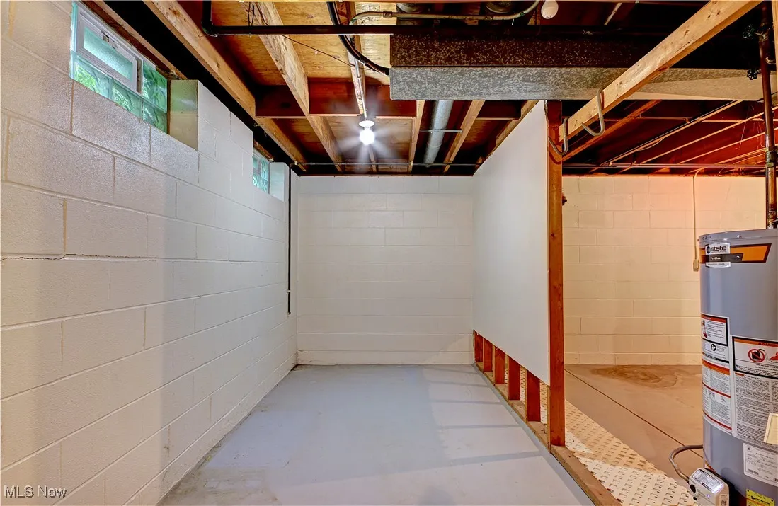 Basement with gas water heater and concrete block wall