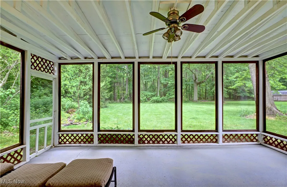 Unfurnished sunroom with a ceiling fan and healthy amount of natural light