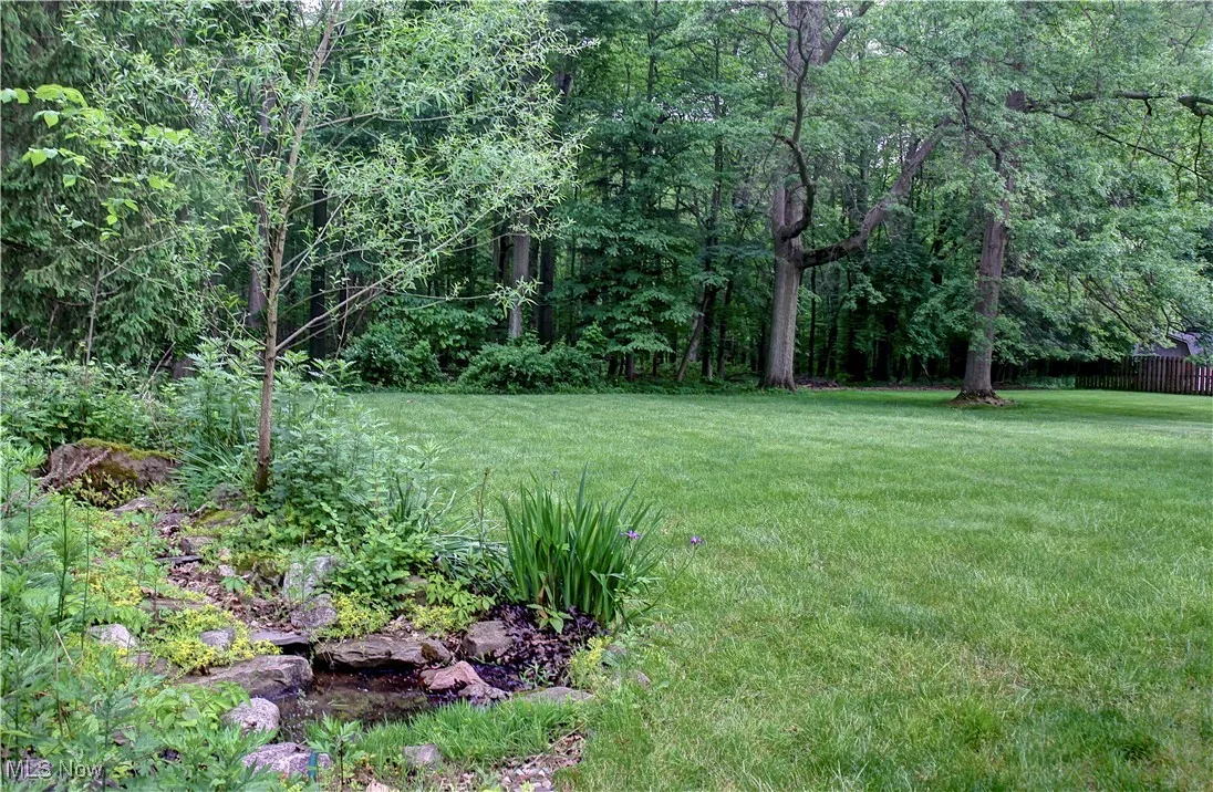 View of grassy yard featuring a view of trees
