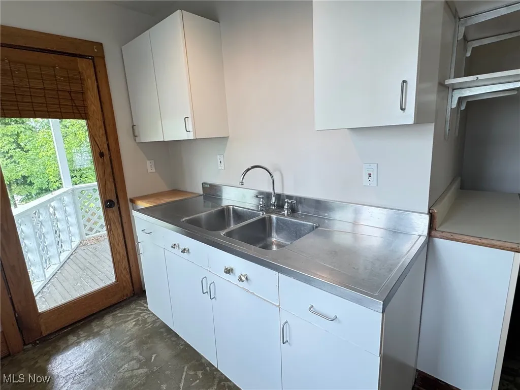 2nd floor Kitchen featuring stainless steel countertops, a sink, and white cabinets