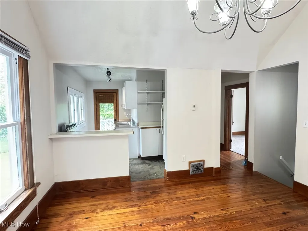 2nd floor dining room with vaulted ceiling, dark wood-type flooring, a sink, healthy amount of natural light, and a chandelier