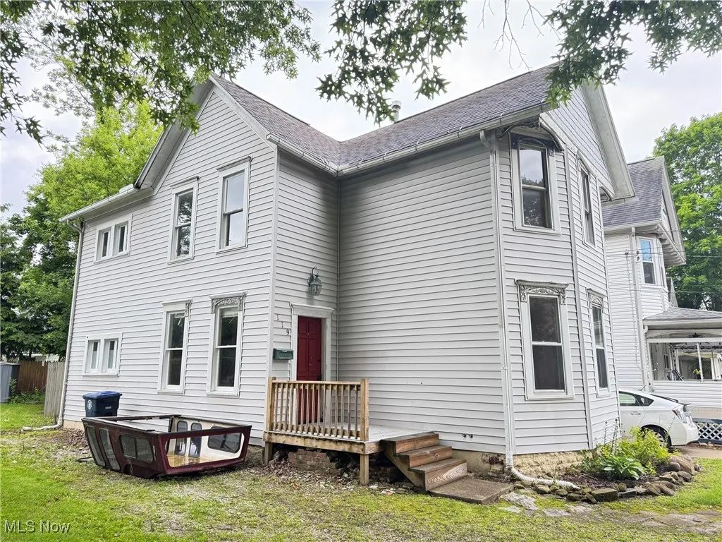 Back of house with a shingled roof