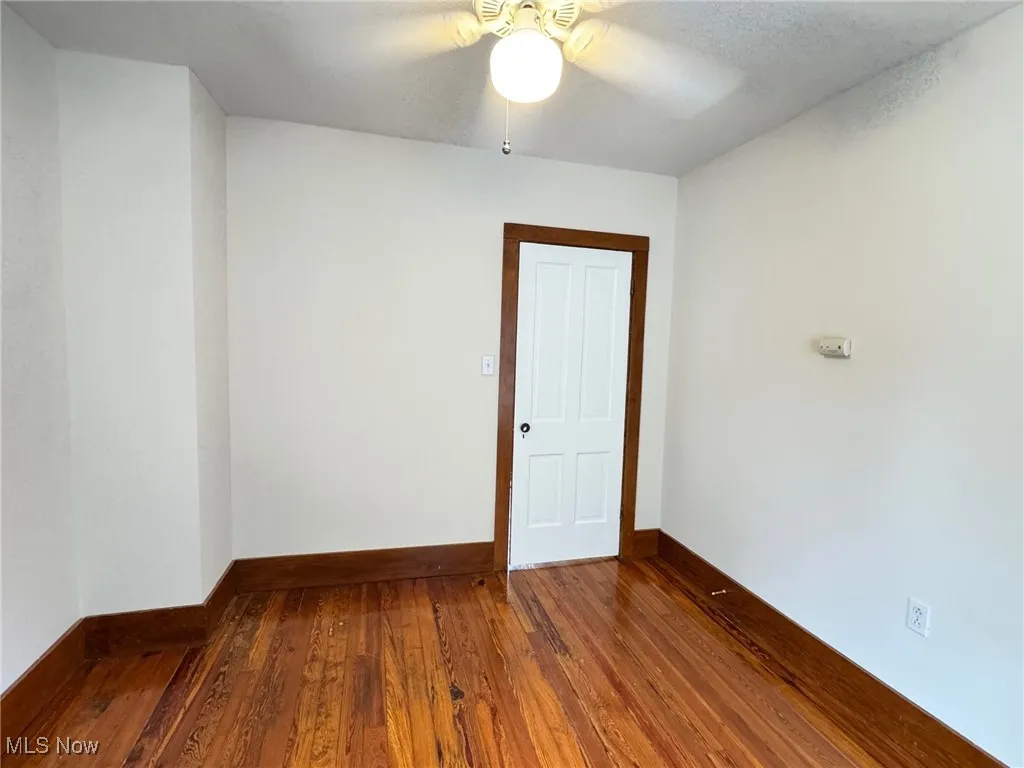 2nd floor bedroom with wood-type flooring, a ceiling fan, and baseboards