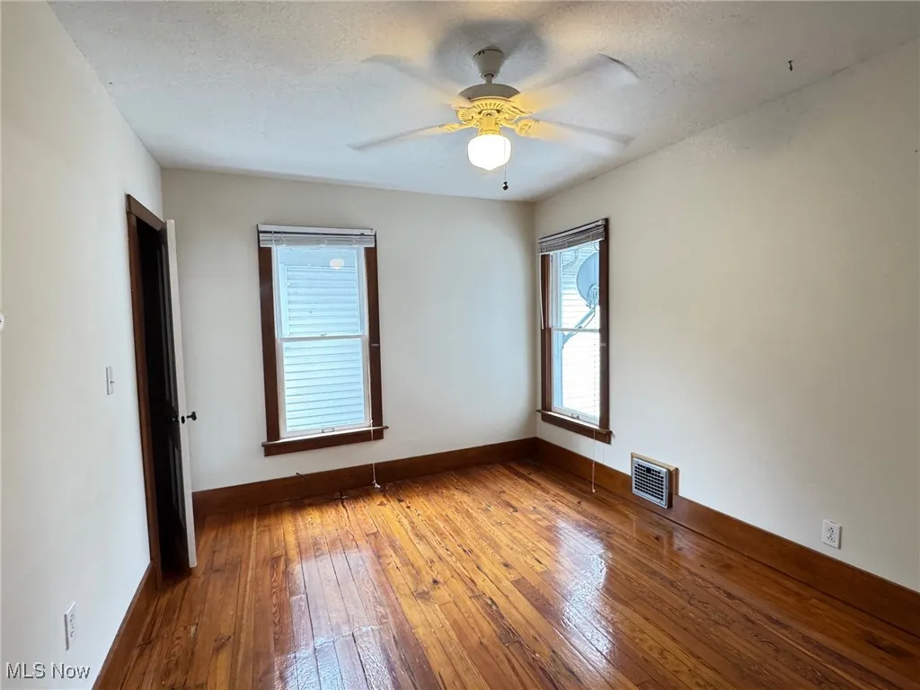 2nd fl bedroom with hardwood / wood-style flooring, ceiling fan, baseboards, and a textured ceiling