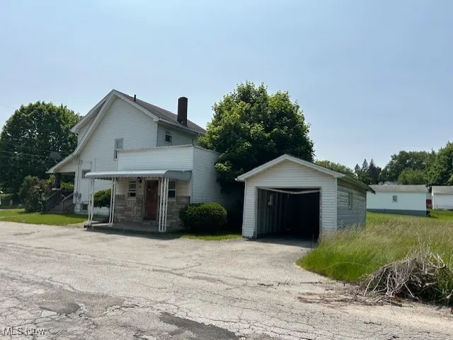 View of front of property with an outbuilding and a garage